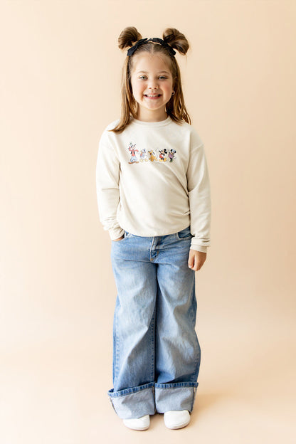 Young girl in mickey and friends sweatshirt and jeans