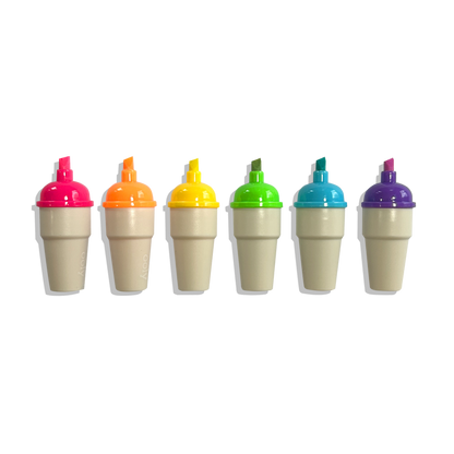 Row of 6 uncapped OOLY Sweet Scoops Scented Neon Highlighters on a white background