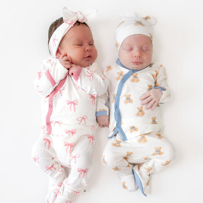 2 babies in take me home sets in a bow pattern and teddy bear pattern