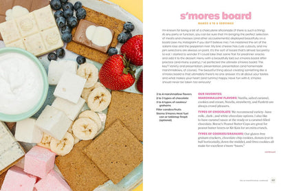 S'mores board with graham crackers, marshmallows, bananas, strawberries, and blueberries on a white plate.
