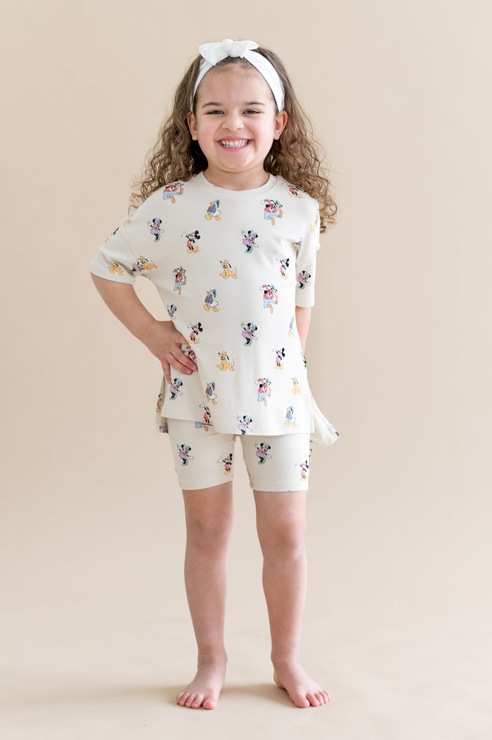 girl wearing a biker short matching set with a mickey and friends pattern