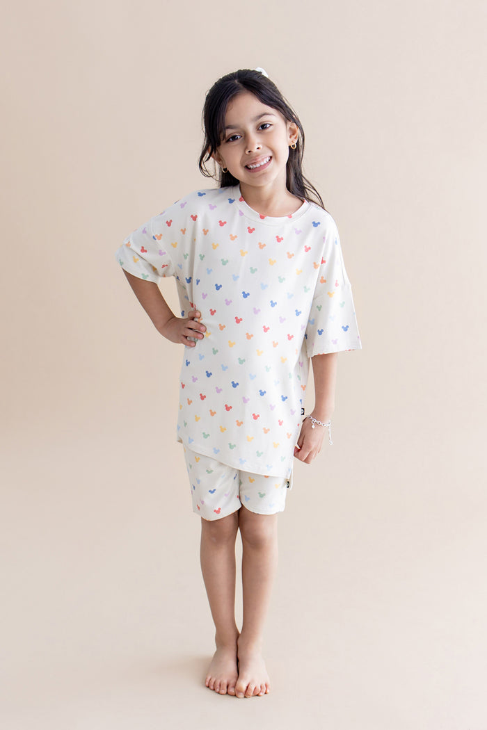 Girl in biker short set with a colorful pattern of mickey heads