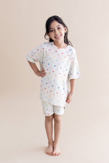 Girl in biker short set with a colorful pattern of mickey heads