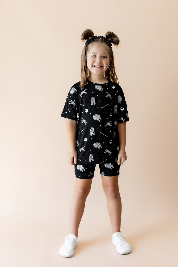 Young girl modeling the Toddler Biker Short Set in STAR WARS™  paired with white shoes