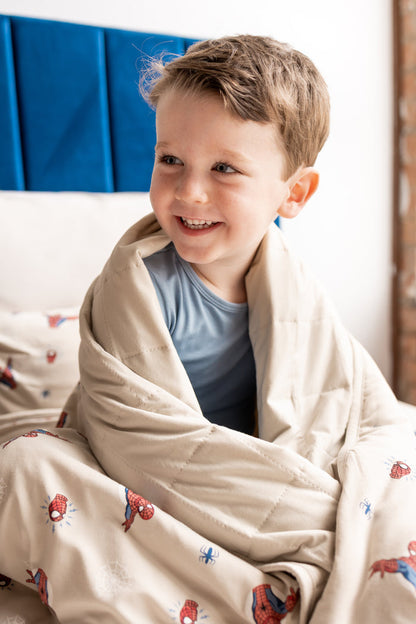 Boy wrapped in oat color Toddler Blanket with Spider-Man print