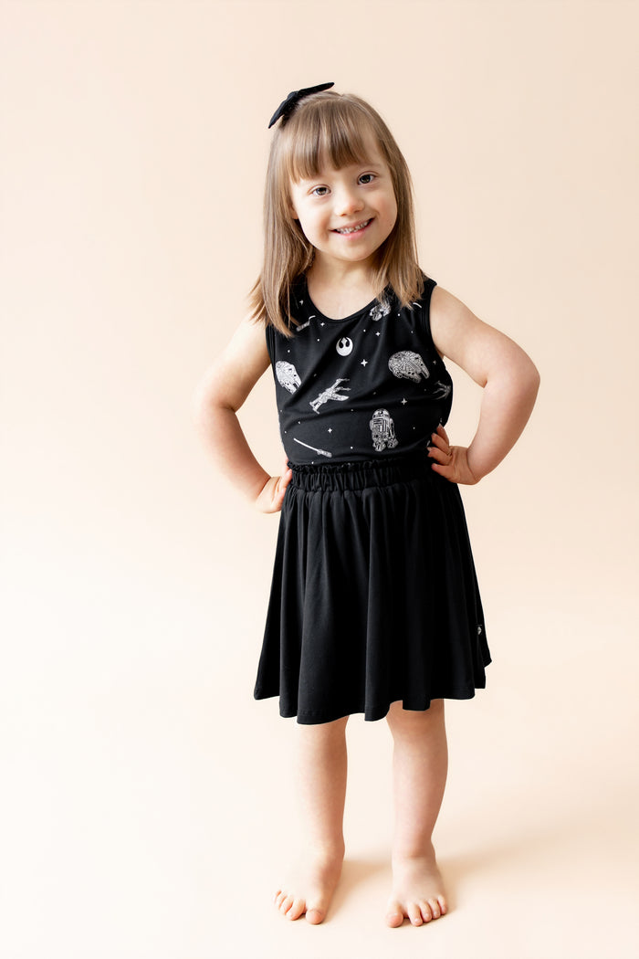 Young girl posing wearing the Toddler Tank Top in STAR WARS™ with a black skort