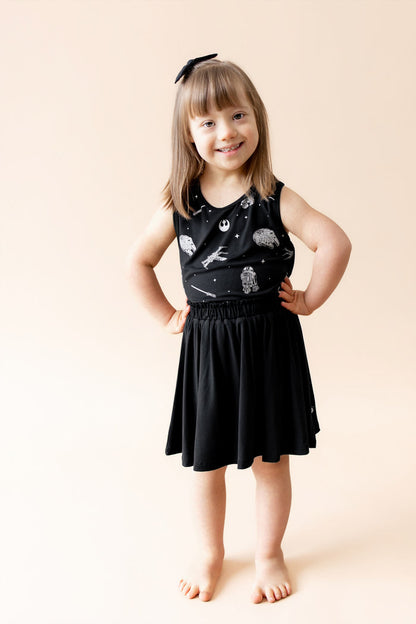 Young girl posing wearing the Toddler Tank Top in STAR WARS™ with a black skort