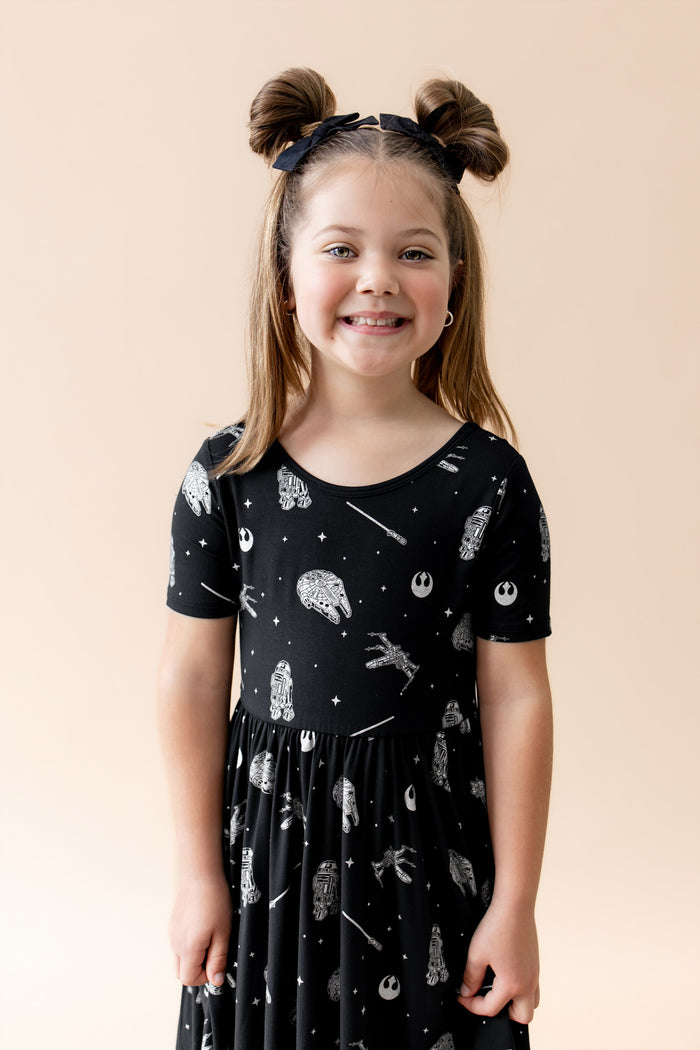 Close up of young smiling girl wearing the Twirl Dress in STAR WARS™