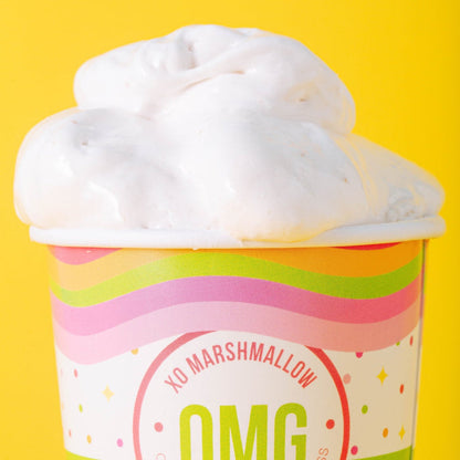 A zoomed in cropped photo of a cloud of vegan marshmallow creme spilling out of it's ice cream pint container with a bright yellow background.