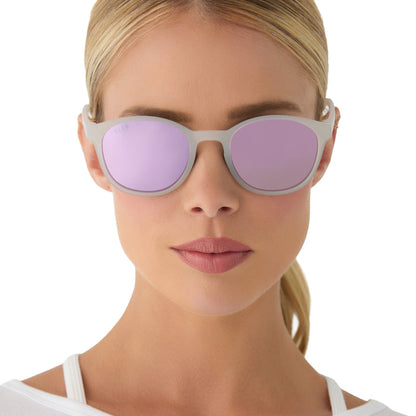 on model - female wearing diff sport featuring the volley round sunglasses with a frosty matte crystal frame and lavender mirror polarized lenses front view