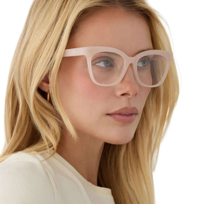 on model - female wearing diff eyewear featuring the winston cateye prescription glasses with a milky blush frame angled view