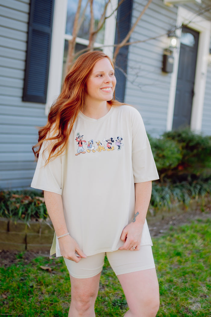 Woman wearing a biker short set with mickey and friends placement across the chest