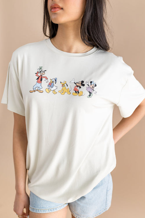 Woman wearing jean shorts and graphic tee with mickey and friends