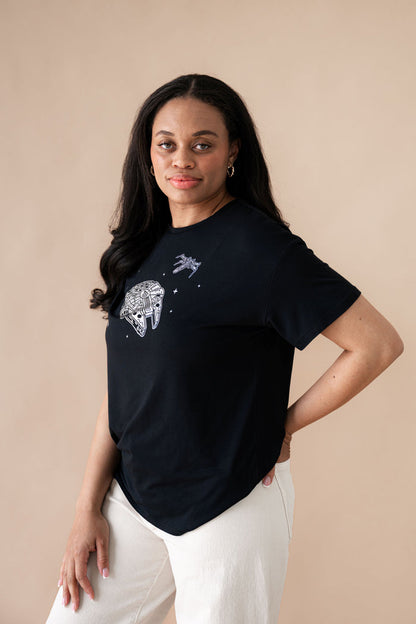 Female standing with one hand on her hip wearing the Women's Graphic Tee in Millennium Falcon™