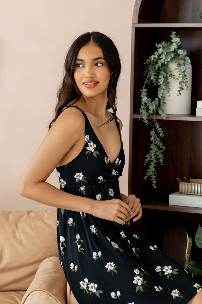 Model posing in Women's Nightgown in Big Midnight Magnolia print sitting on beige sofa side