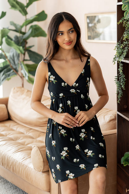 Model smiling in Women's Nightgown in Big Midnight Magnolia print sitting on beige sofa side