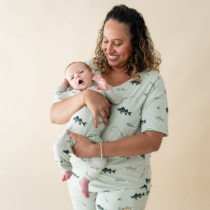 Woman wearing Kyte Baby Women's Relaxed Fit V-Neck in Fishing with Infant in matching romper