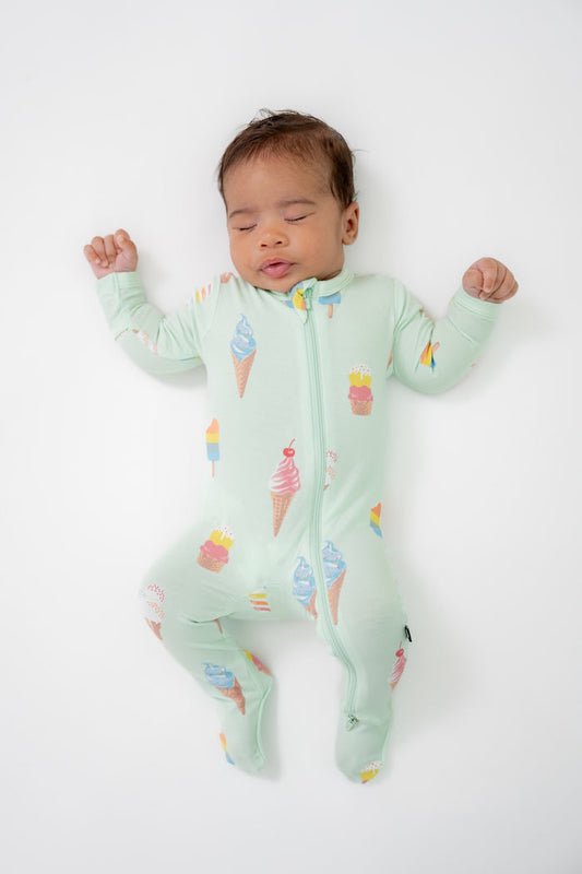 Baby sleeping in Zippered footie in Mint Ice cream print on a beige background